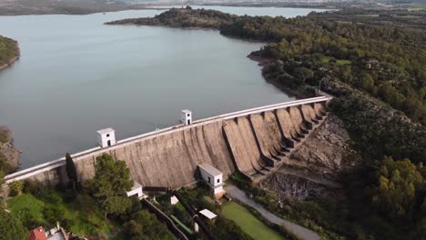 Dam-containing-large-water-lake,-high-aerial-drone-view,-Tratalias,-Sardinia