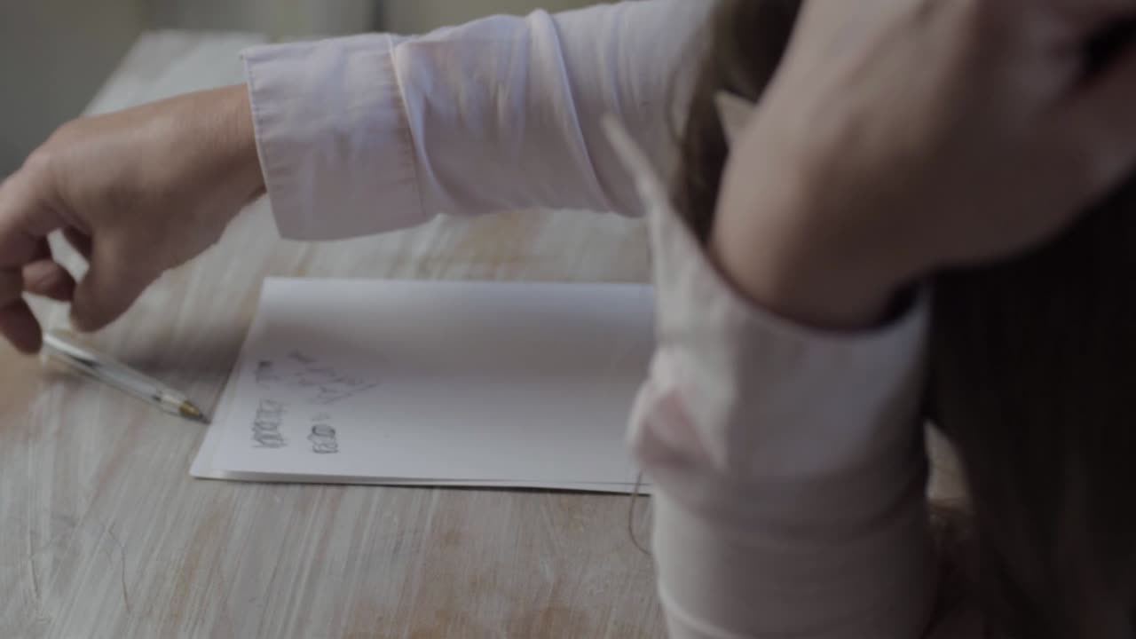 скучающая женщина сидит на столе и рисует