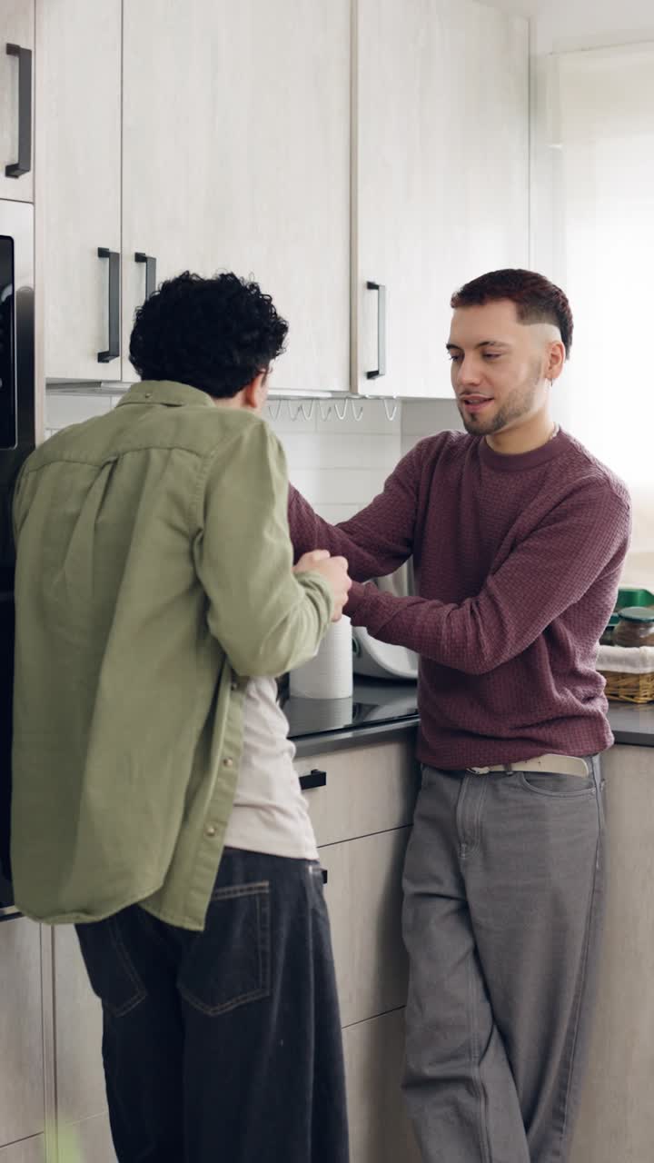 Due giovani uomini parlano e condividono un momento in una cucina moderna
