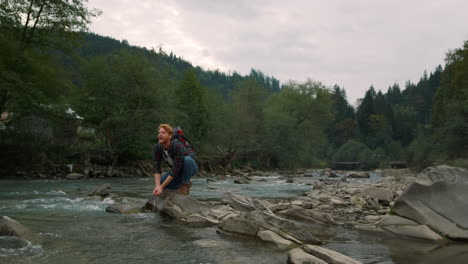 tourist taking water in hands from river. man splashing water from hands in air