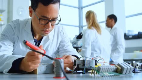 male scientist soldering circuit board 4k