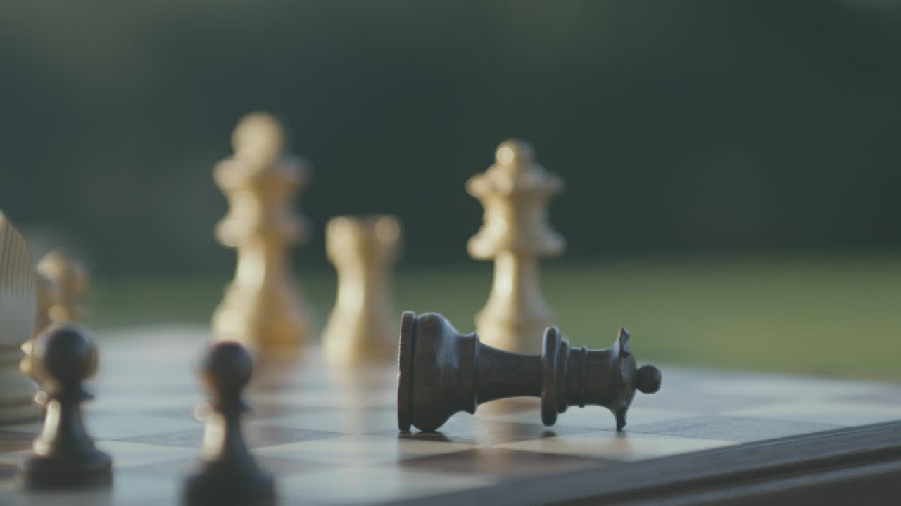 한 손이 검은 여왕을 잡고 떨어뜨린다, 체스 게임