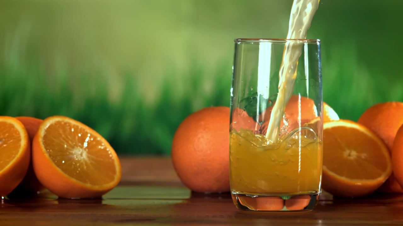 Fresh Orange Juice Pouring into a Glass in Slow Motion