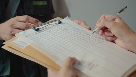 hands of female recipient signing document and taking mail from courier