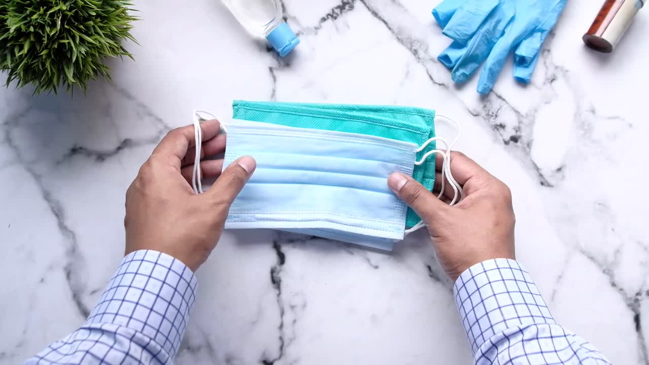 manos con máscaras faciales y equipos de protección