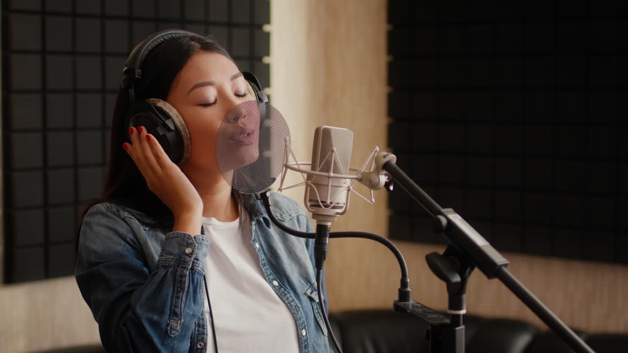 녹음 스튜디오 에서 마이크 로 노래 하는 여자