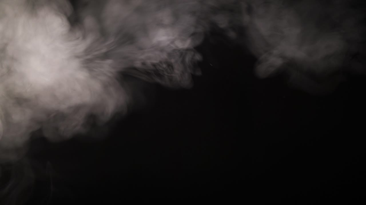Fumo bianco che sale e si dissolve su sfondo nero