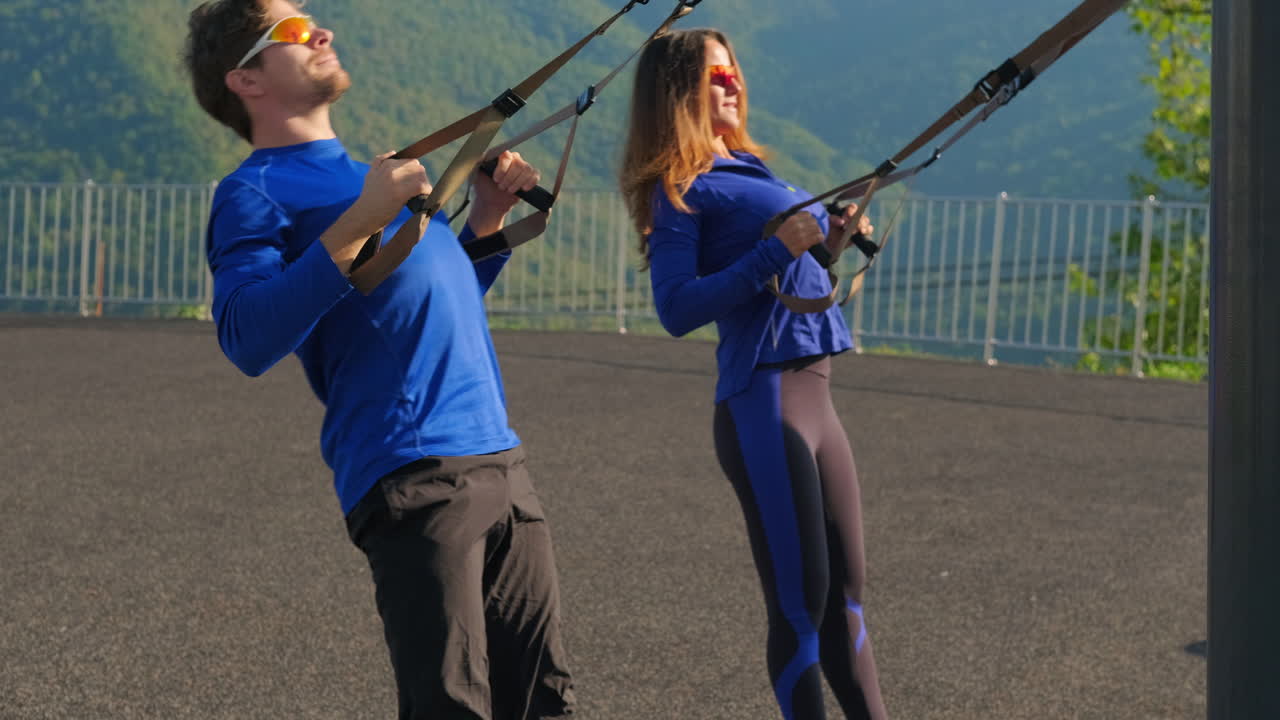 pareja trabajando con entrenamiento de suspensión trx