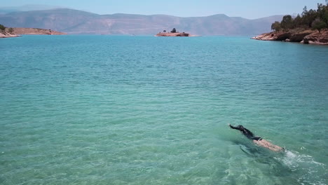 Una-Joven-Nada-Sin-Esfuerzo-A-Través-De-Las-Brillantes-Aguas-Color-Aguamarina-Del-Golfo-De-Corinto,-Grecia