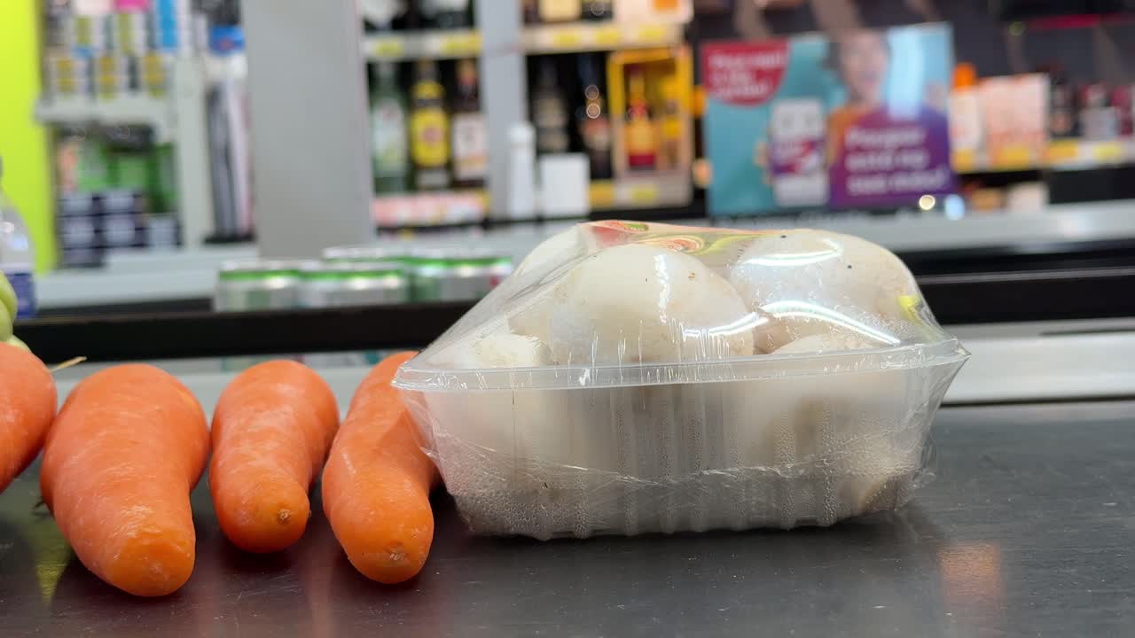 Grocery store produce display with mushrooms and carrots