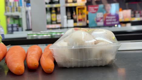 grocery store produce display with mushrooms and carrots