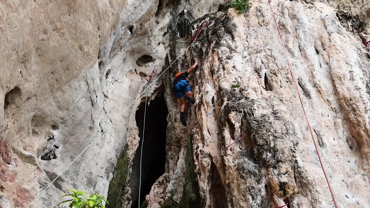 un escalador sube a un acantilado de piedra caliza en krabi, tailandia