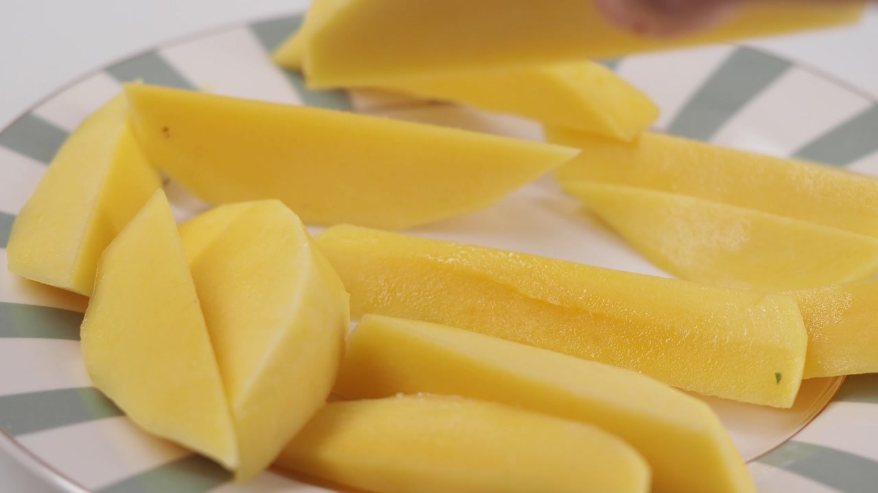 Hand Picking Up a Peeled Raw Potato Wedge