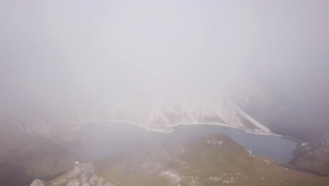 foggy drone flight in alps lünersee lake in austria vorarlberg