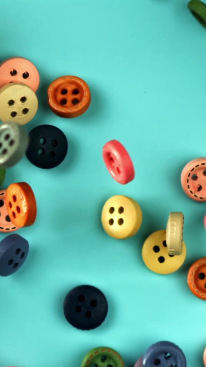 Vibrant Craft Buttons Falling in Slow Motion on a Blue Background