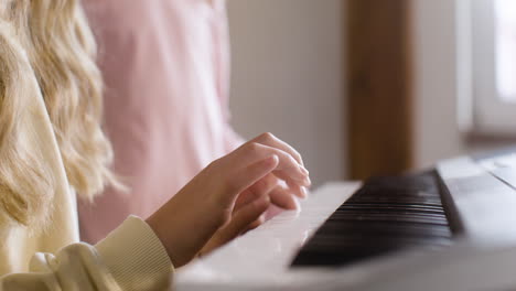 Primer-Plano-De-Una-Chica-Rubia-Tocando-El-Teclado-Del-Piano-En-La-Escuela