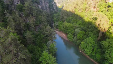 FPV-drone-flight-over-natural-river-with-resting-people-on-sandy-shoreline-in-Lebanon,Asia