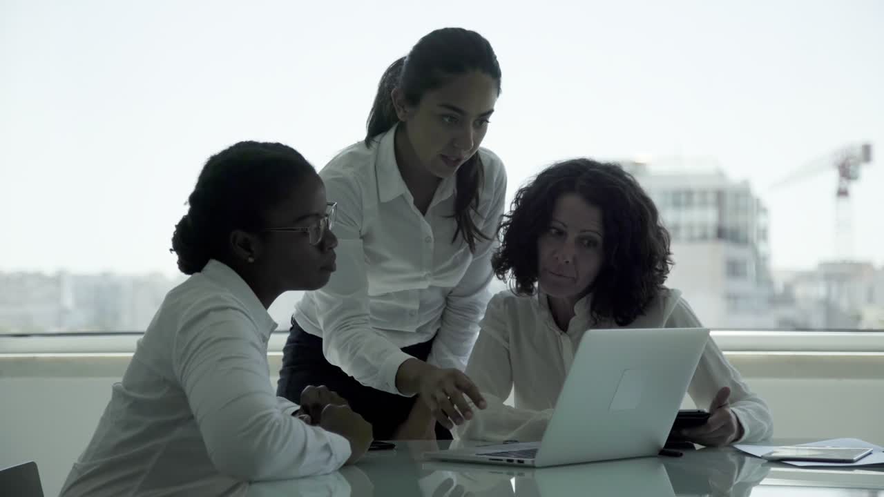 Focused businesswomen working with laptop