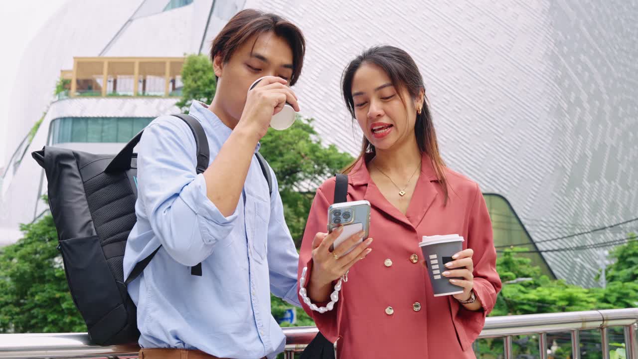 คู่รักก าลังมองสมาร์ทโฟนพร้อมกาแฟในเมือง