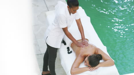 a young woman getting a back massage at a spa