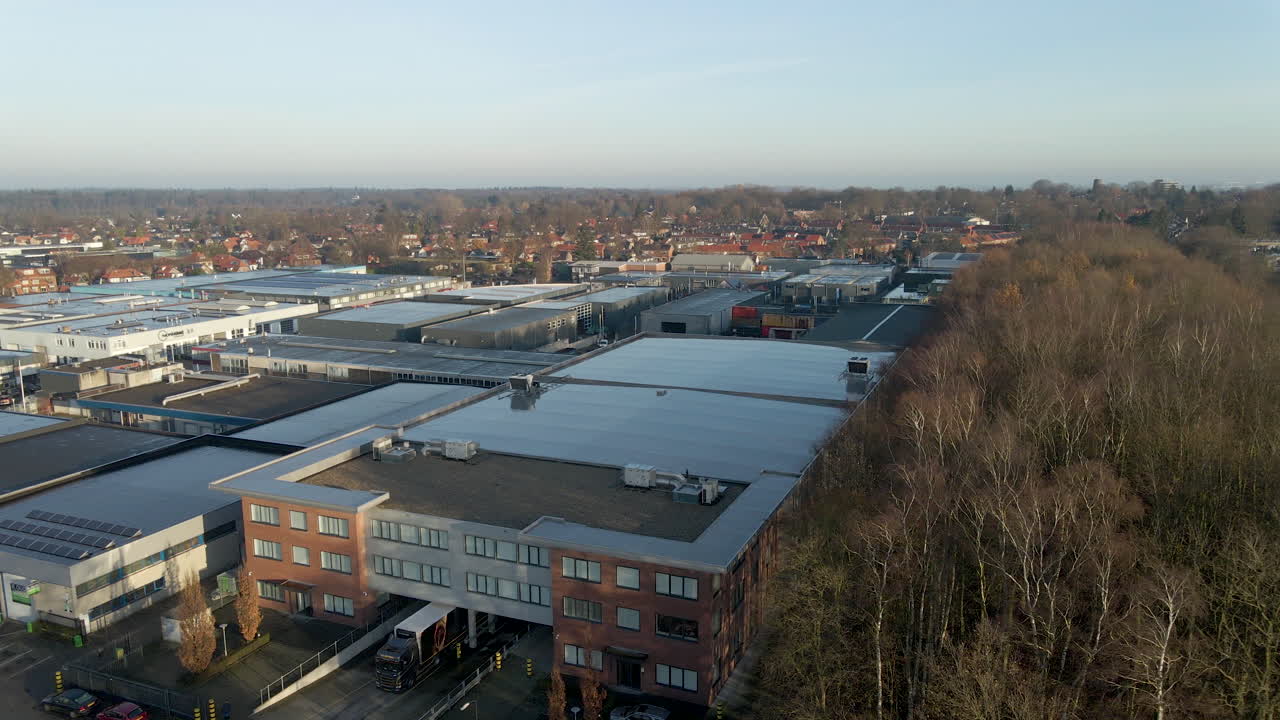 Aerial up of solar panels on industrial building near forest