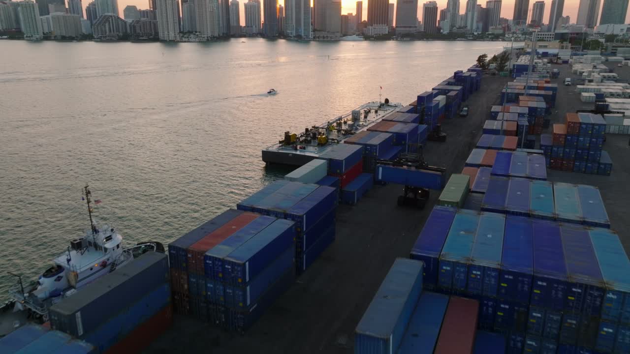 포워드 는 항구 에 쌓여 있는 해외 컨테이너 의 줄 위 를 날아다니며, 해 가 지는 태양 을 배경 으로 하이라인 을 드러 ⁇ 니다. 마이애미, 미국