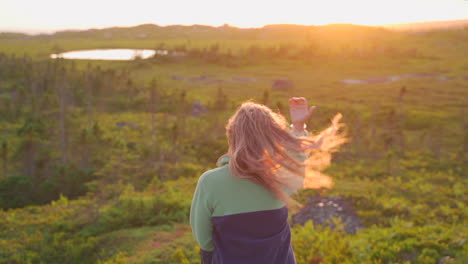 Frau,-Die-Auf-Felsen-In-Der-Wildnis-In-Der-Goldenen-Stunde-Sonnenuntergang-Lächelnd-Sitzt