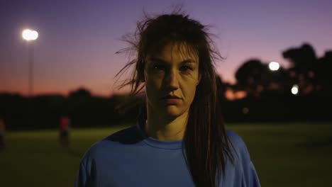 Female-soccer-player-smiling-while-holding-ball-on-soccer-field.-4k