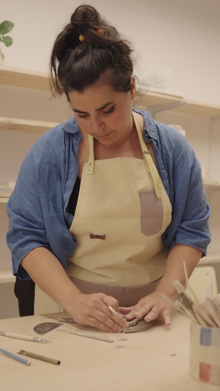 mujer trabajando con arcilla en el estudio de cerámica