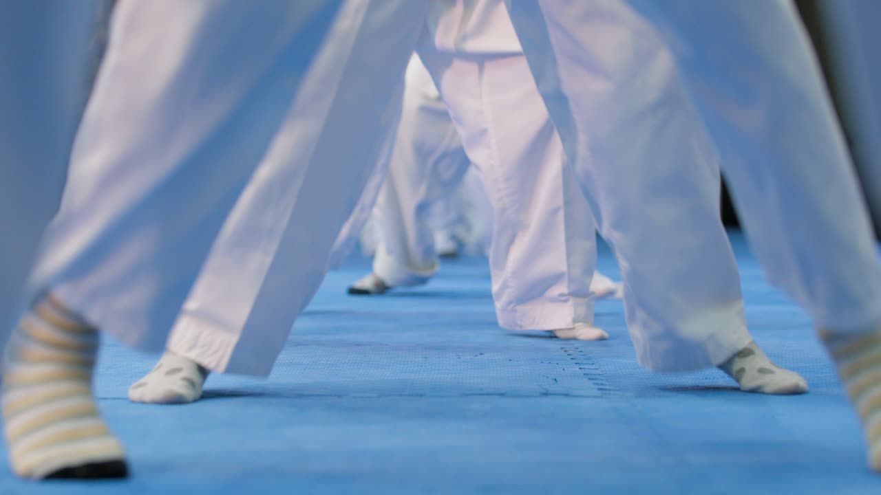 primer plano de varios niños en karate kimono saltando y cambiando de postura en el sitio