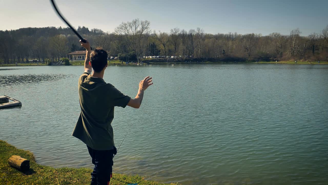 잉어를 유인하기 위해 물에 미끼를 던지는 도구를 사용하는 사람의 느린 동작