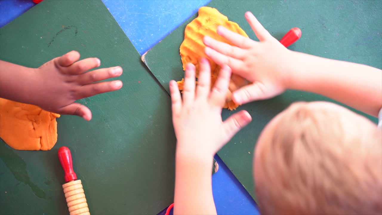 African and Caucasian children playing with playdough in Montesorri school