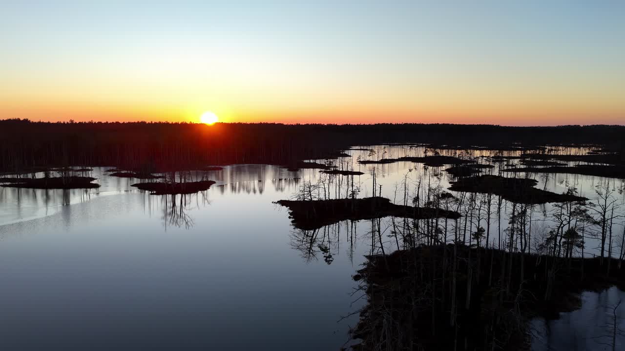 En vacker solnedgång över en sjö med några träd i bakgrunden