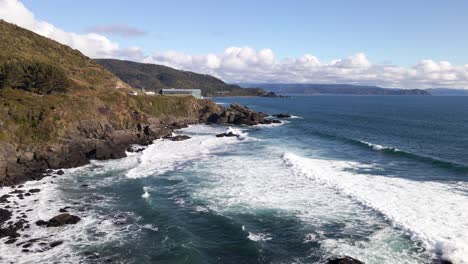 toma aérea de las olas rompiendo en las rocas de la costa