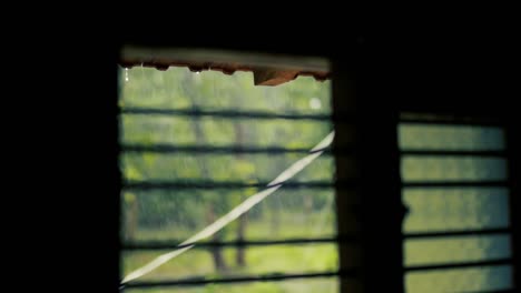 raindrops dripping from roof seen from window. static, shallow focus