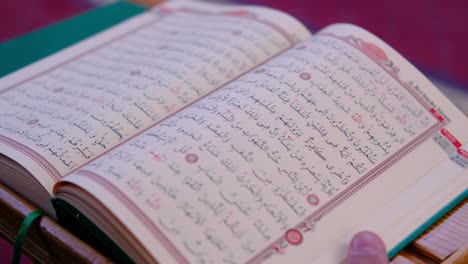 Nahaufnahme-Der-Hände-Des-Mannes,-Die-Koran-In-Der-Moschee-Halten