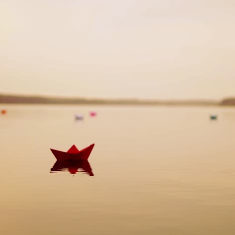 paper boats floating in the river. beautiful summer sunset. origami.