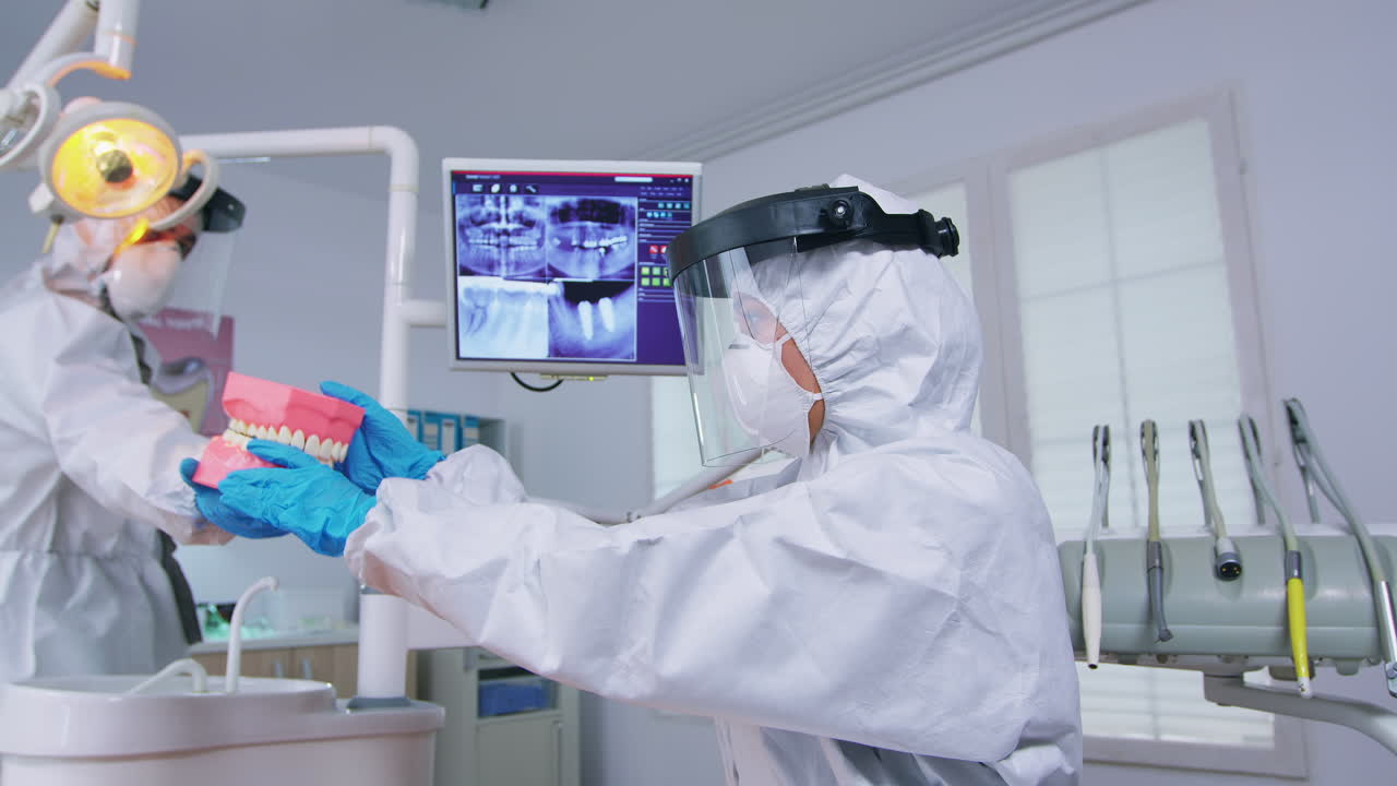 paciente del equipo médico del dentista enseñando al niño a limpiar los dientes