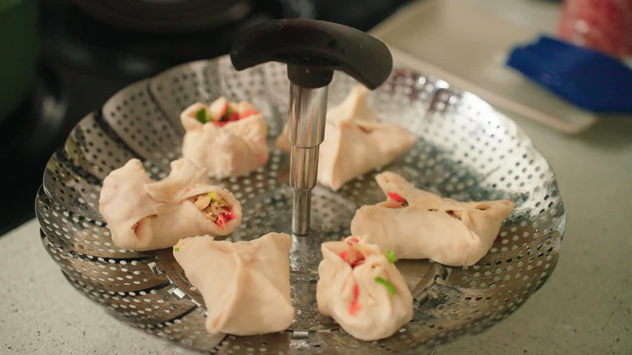Steaming fresh made dumplings in a boiling pot of water