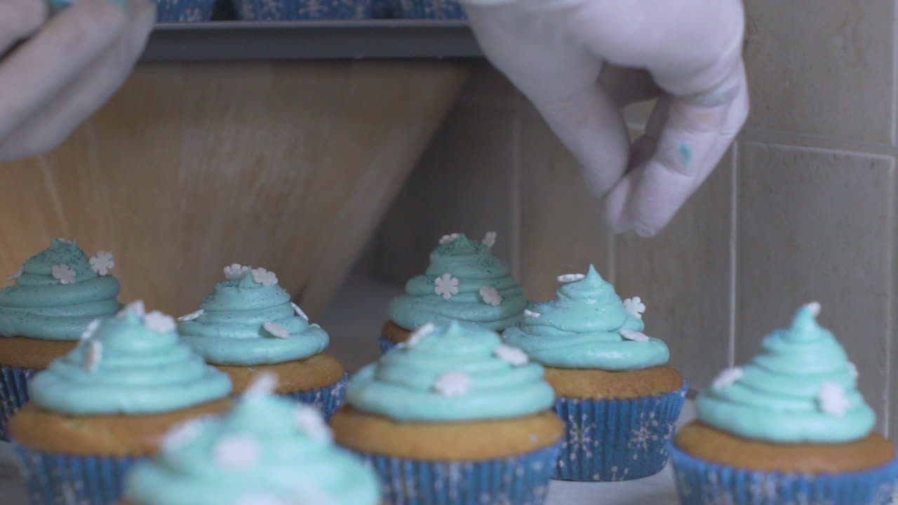 Mulher decorando cupcakes, usando luvas de látex brancas a 120fps