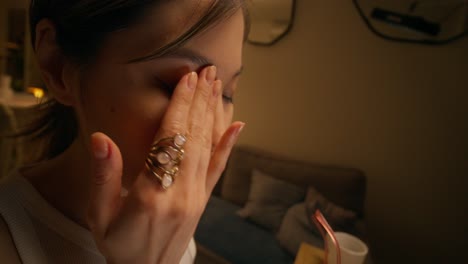 woman applying eye cream at night