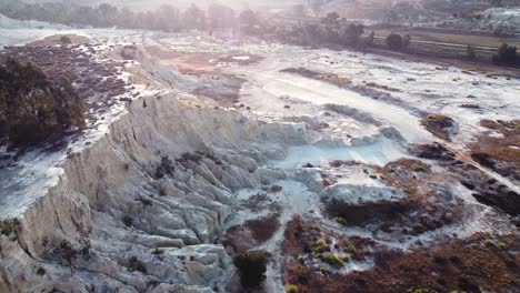 aerial drone shot tracking backwards over an old gold mine dump where the tailings are being recycled using modern technology, benoni, south africa