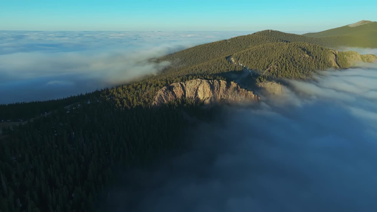 Rolling cloud layers touching Colorado mountain peaks near Juniper Pass, dramatic high altitude backdrop