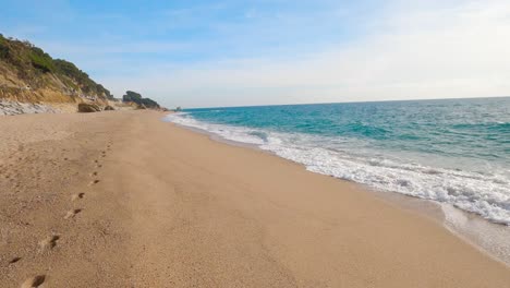 walking,walking-in-the-sand,calm-mediterranean-sea,barcelona-spain,-footprints-in-the-sand