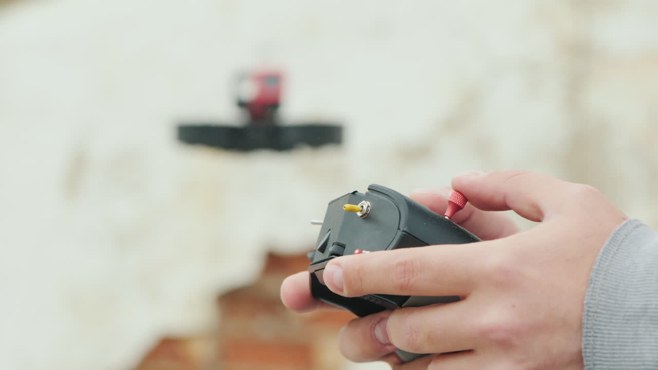 배경에 컨트롤 패널이 있는 시네드론 조종사의 손에 날아다니는 박사를 볼 수 있습니다.