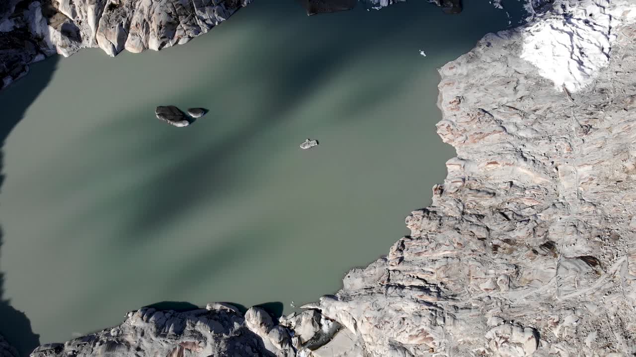 빙하 호수에서 산봉우리 아래의 얼음까지 팬이 있는 스위스의 발레와 우리의 경계에 있는 푸르카 산길 근처의 론 빙하의 공중 전망