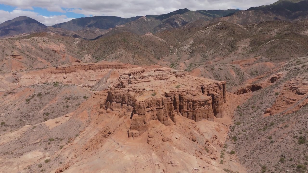 Drone ascend reveals landscape and ridges of Los Castillos sandstone formation in Quebrada de las Flechas, aerial