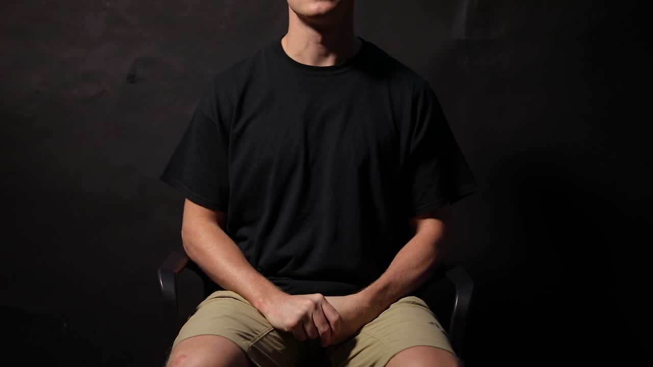 foto de un hombre sentado en una silla frotándose las manos