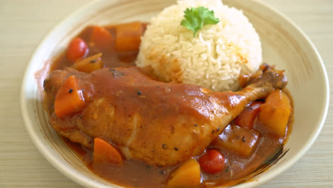 homemade chicken stew with tomatoes, onions, carrot and potatoes on plate with rice