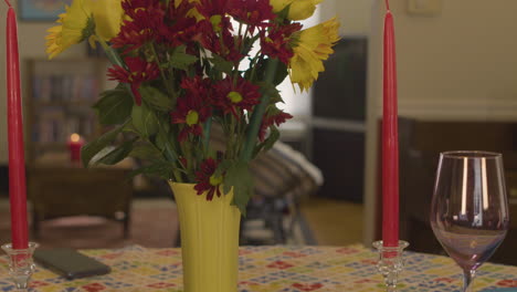 abajo un ramo de flores y una vela preparándose para una cena romántica